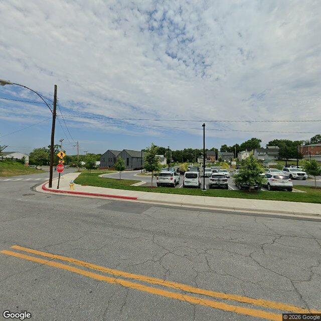 The northeast corner of North Commerce and West Salisbury, July 2024. New asphalt, marked spaces, young trees.