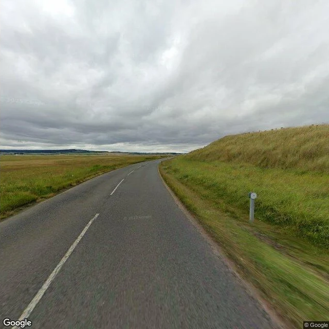 the way back — the same dry causeway road from the other direction, the tide marker pole in frame, 2024-08